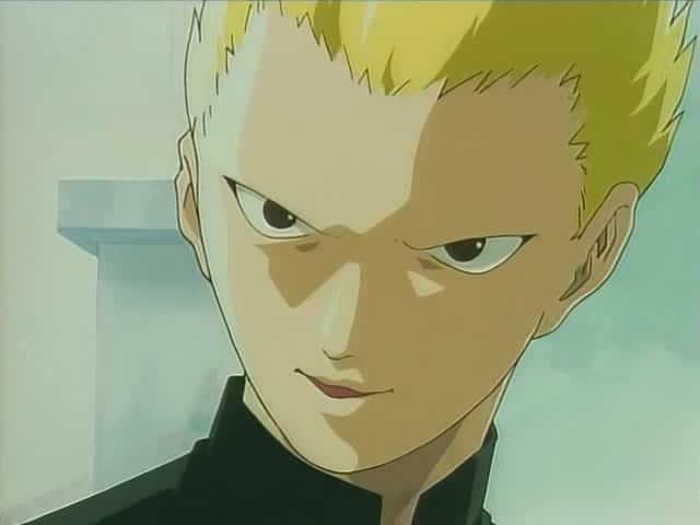 Primer plano de un sonriente Yuji Takehisa, personaje de Angel Densetsu. Rubio, con uniforme escolar.